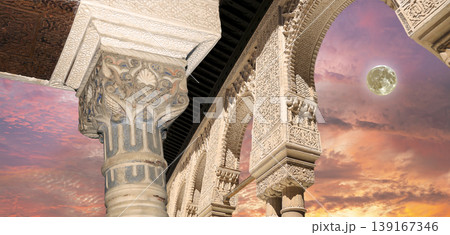 Arches in Islamic (Moorish) style (against the sunset with the super moon) in Alhambra, Granada, Spain Arches in Islamic (Moorish) style (against the sunset with the super moon) in Alhambra, Granada, Spain 139167346