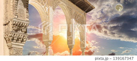 Arches in Islamic (Moorish) style (against the sunset with the super moon) in Alhambra, Granada, Spain Arches in Islamic (Moorish) style (against the sunset with the super moon) in Alhambra, Granada, Spain 139167347