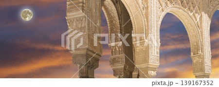 Arches in Islamic (Moorish) style (against the sunset with the super moon) in Alhambra, Granada, Spain  139167352