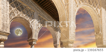 Arches in Islamic (Moorish) style (against the sunset with the super moon) in Alhambra, Granada, Spain        139167655