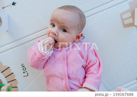 Close-up of three month old baby sucking fist. Self soothing behavior, teething and early development concept. Infant calming by sucking hand. Natural reflex, comfort and sensory development. 139167886