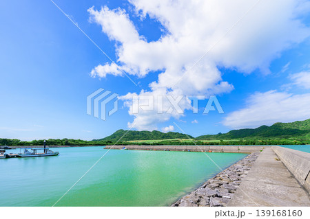 石垣島　青空と緑の山並みに囲まれた船越漁港の防波堤 139168160
