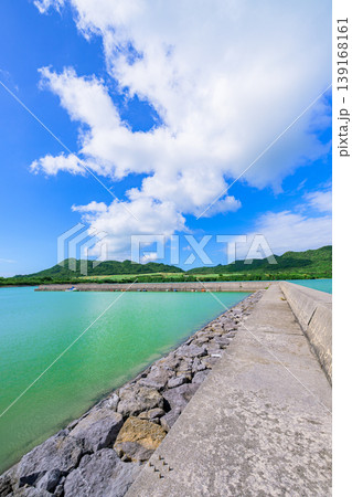 石垣島 青空と緑の山並みに囲まれた船越漁港の防波堤 石垣島 青空と緑の山並みに囲まれた船越漁港の防波堤 139168161