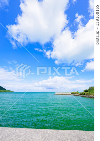 石垣島　青空と緑の山並みに囲まれた船越漁港の防波堤 139168165