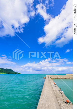 石垣島　青空と緑の山並みに囲まれた船越漁港の防波堤 139168176