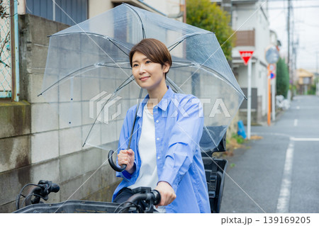 傘をさして自転車に乗る女性 139169205
