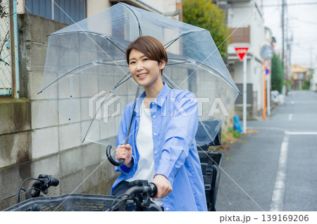 傘をさして自転車に乗る女性 139169206