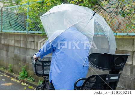 傘をさして自転車に乗る女性 139169211