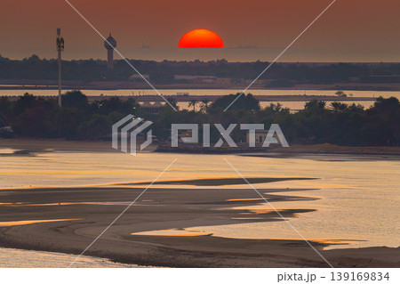 Sir Bani Yas island, United Arab Emirates, a panoramic view of island nature and sea with mangroves trees, with some of buildings on background, with orange sky at sunset 139169834