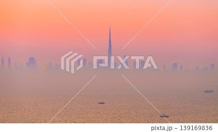 Dubai, United Arab Emirates - Jan 12 2024, Panoramic view of downtown Dubai skyscrapers, with Burj Khalifa in the middle, at dawn in a haze, a view from the sea, Dubai, United Arab Emirates Dubai, United Arab Emirates - Jan 12 2024, Panoramic view of downtown Dubai skyscrapers, with Burj Khalifa in the middle, at dawn in a haze, a view from the sea, Dubai, United Arab Emirates 139169836