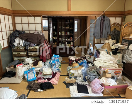 ゴミ屋敷となった認知症で施設に入った空き家の残置物片づけ前で呆然と大変さを嘆く 139171927