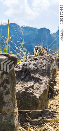 large rock at the top of the hill with a beautiful view in the background 139172443