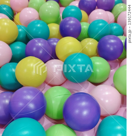 A variety of small, colorful plastic balls that create a fun and lively atmosphere. A variety of small, colorful plastic balls that create a fun and lively atmosphere. 139172444