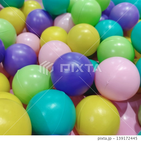 A variety of small, colorful plastic balls that create a fun and lively atmosphere. A variety of small, colorful plastic balls that create a fun and lively atmosphere. 139172445