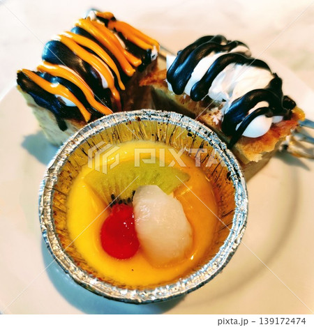 A close-up of a plate with two pieces of cake and a fork, highlighting a tempting dessert presentation 139172474