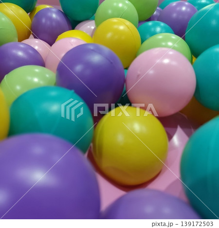 A variety of small, colorful plastic balls that create a fun and lively atmosphere. A variety of small, colorful plastic balls that create a fun and lively atmosphere. 139172503