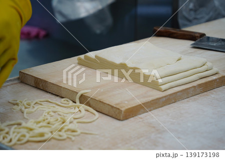 Traditional Korean Hand-cut Noodles Preparation on a Wooden Cutting Board, Kalguksu Traditional Korean Hand-cut Noodles Preparation on a Wooden Cutting Board, Kalguksu 139173198