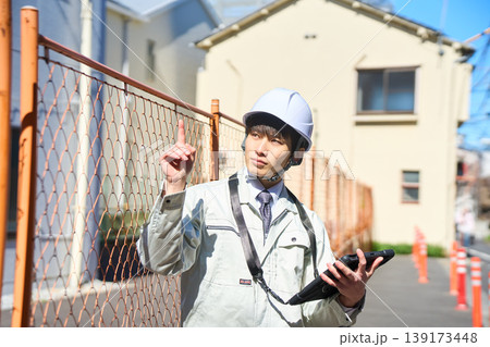 タブレットを手に持ち建設現場の状況を確認する男性現場監督 タブレットを手に持ち建設現場の状況を確認する男性現場監督 139173448