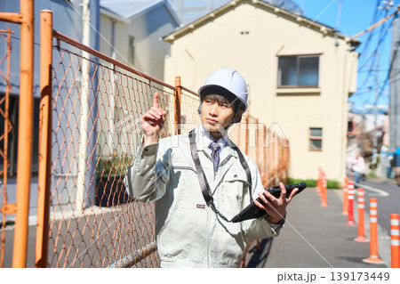タブレットを手に持ち建設現場の状況を確認する男性現場監督 タブレットを手に持ち建設現場の状況を確認する男性現場監督 139173449