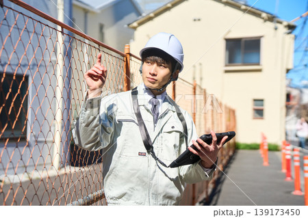 タブレットを手に持ち建設現場の状況を確認する男性現場監督 タブレットを手に持ち建設現場の状況を確認する男性現場監督 139173450