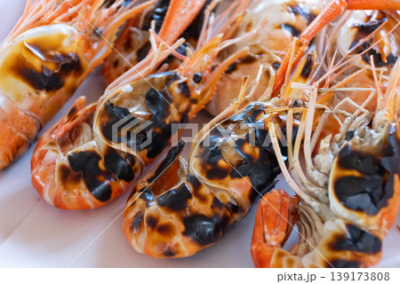 Close up grilled river prawns with charred shells on white plate juicy seafood texture rich flavor Asian cuisine appetizing dish fresh cooked and ready to serve 139173808