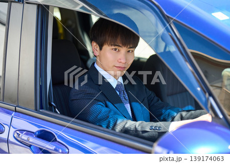営業車の運転席から窓越しにカメラを見つめる若い日本人ビジネスマン 営業車の運転席から窓越しにカメラを見つめる若い日本人ビジネスマン 139174063