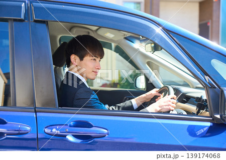 自動車の運転席で前を向き安全運転を心がけるスーツ姿の日本人ビジネスマン 自動車の運転席で前を向き安全運転を心がけるスーツ姿の日本人ビジネスマン 139174068