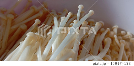 A group of Enoki mushrooms (Flammulina velutipes), also known as golden needle mushrooms. A group of Enoki mushrooms (Flammulina velutipes), also known as golden needle mushrooms. 139174158