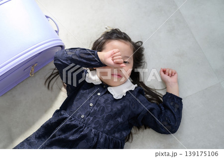 床に寝転んで眠そうなランドセルの日本人の女の子 139175106