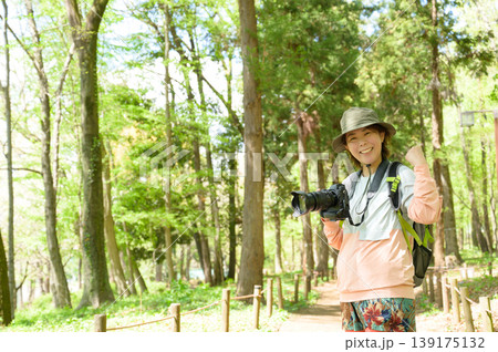 山でカメラを持ってガッツポーズをする日本人女性 山でカメラを持ってガッツポーズをする日本人女性 139175132