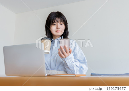 カフェでパソコン。スマートフォンを使う女性 139175477