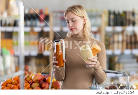 Young woman chooses sauces in grocery store 139175554