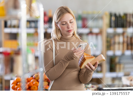 Young woman scanning qr code for cheese Young woman scanning qr code for cheese 139175557