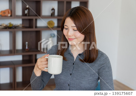 自宅でコーヒーを楽しむリラックスした女性のライフスタイルポートレート 自宅でコーヒーを楽しむリラックスした女性のライフスタイルポートレート 139175607