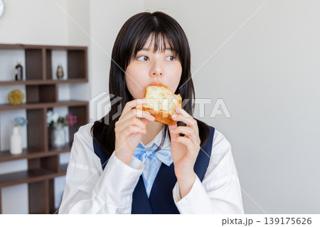 朝食にパンを食べる制服の若い女性・ナチュラルライフスタイル 朝食にパンを食べる制服の若い女性・ナチュラルライフスタイル 139175626