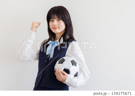 サッカーボールを持ってガッツポーズする女子学生・スポーツと青春イメージ 139175671