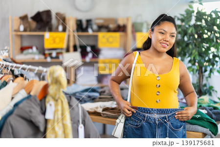 Girl at trading floor pick out and buying jeans trousers Girl at trading floor pick out and buying jeans trousers 139175681