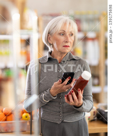 Elderly woman scanning qr code for ketchup Elderly woman scanning qr code for ketchup 139175698