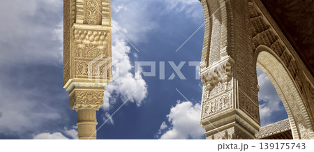 Arches in Islamic (Moorish) style (against the background of a beautiful sky with clouds) in Alhambra, Granada, Spain  139175743