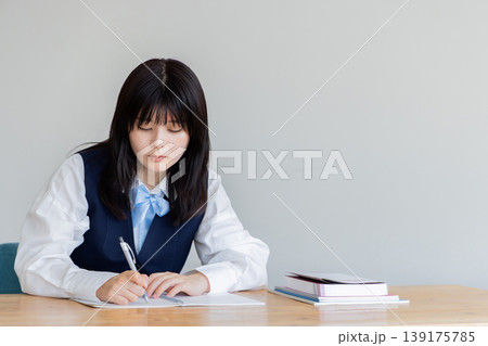 ノートに書きながら考える女子学生の勉強シーン ノートに書きながら考える女子学生の勉強シーン 139175785