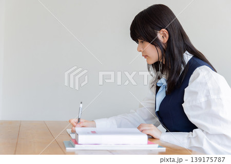 ノートに書き込む横顔の女子学生の勉強風景 139175787