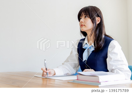 勉強する女子学生のポートレート（ノートと参考書） 139175789