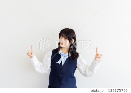 両手で指差しポーズをする女子学生のポートレート（コピースペースあり） 139175793