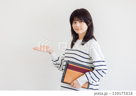 資料を持って案内する若い女性・ビジネスと教育イメージ（コピースペースあり） 139175818