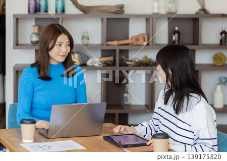 カフェ風オフィスで打ち合わせする若い女性ビジネスパーソン 139175820