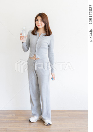 ミネラルウォーターを持つ笑顔の若い女性・健康的なライフスタイルイメージ ミネラルウォーターを持つ笑顔の若い女性・健康的なライフスタイルイメージ 139175827