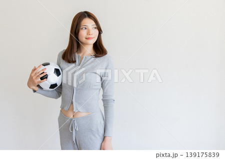 サッカーボールを持つ若い女性・スポーツと健康をイメージしたポートレート サッカーボールを持つ若い女性・スポーツと健康をイメージしたポートレート 139175839