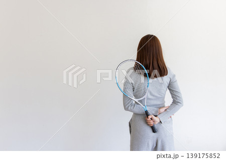 テニスラケットを背中に持つ若い女性・後ろ姿のスポーツライフスタイル テニスラケットを背中に持つ若い女性・後ろ姿のスポーツライフスタイル 139175852