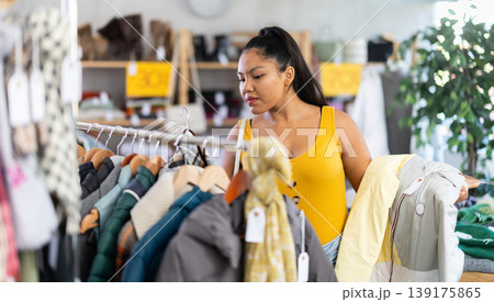 Young woman choosing down jacket in clothing store 139175865