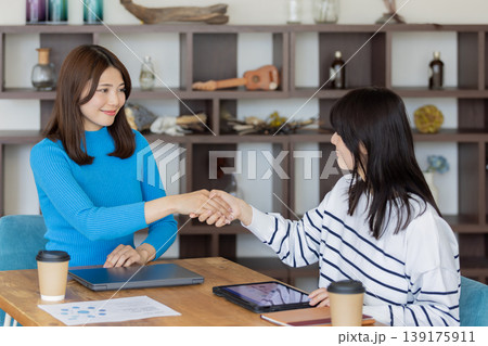ビジネスシーンで握手する若い女性同士のパートナーシップと成功イメージ ビジネスシーンで握手する若い女性同士のパートナーシップと成功イメージ 139175911